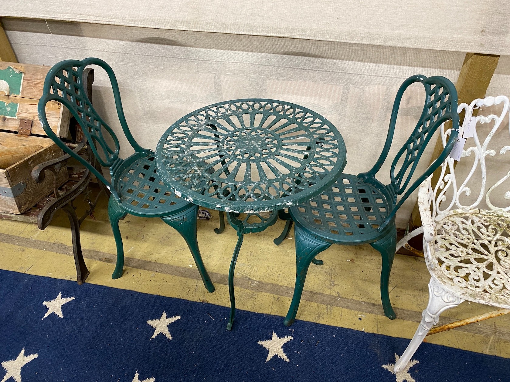 A painted aluminium circular garden table, diameter 62cm, height 67cm and two chairs